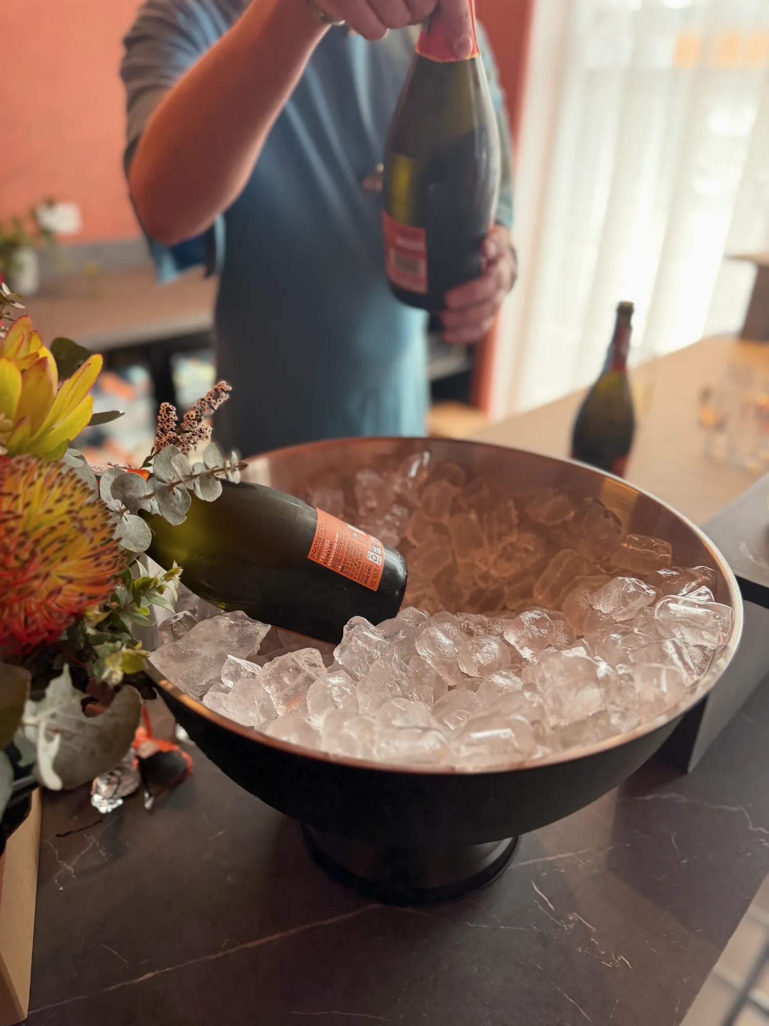 Prosecco on ice beside native proteas