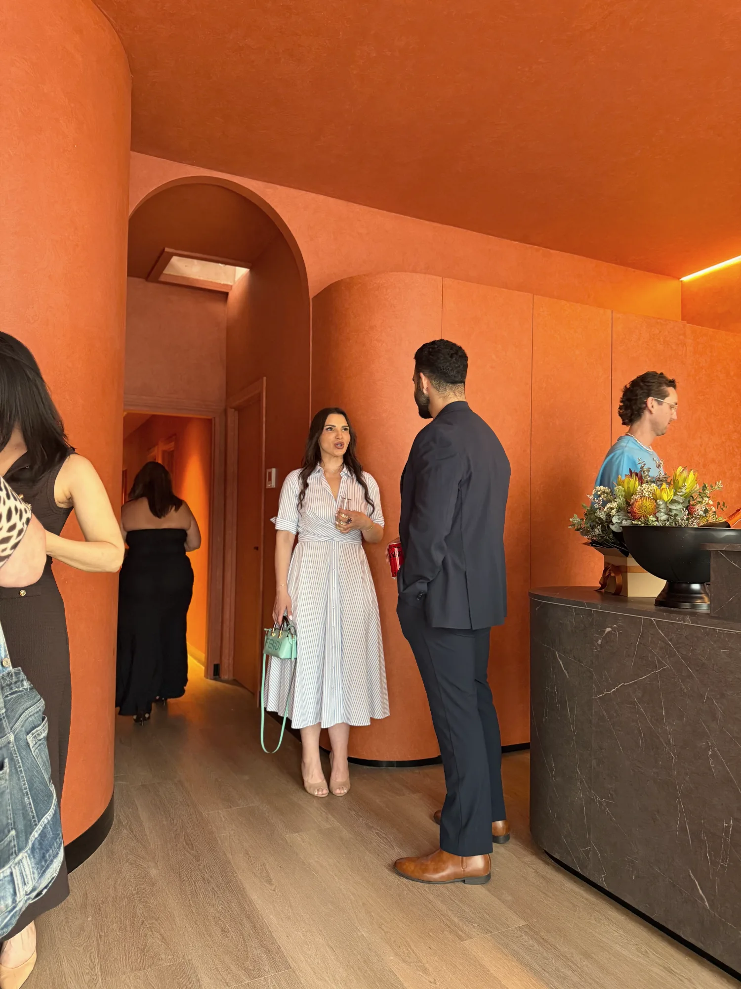 Guests talking beneath the clay archway