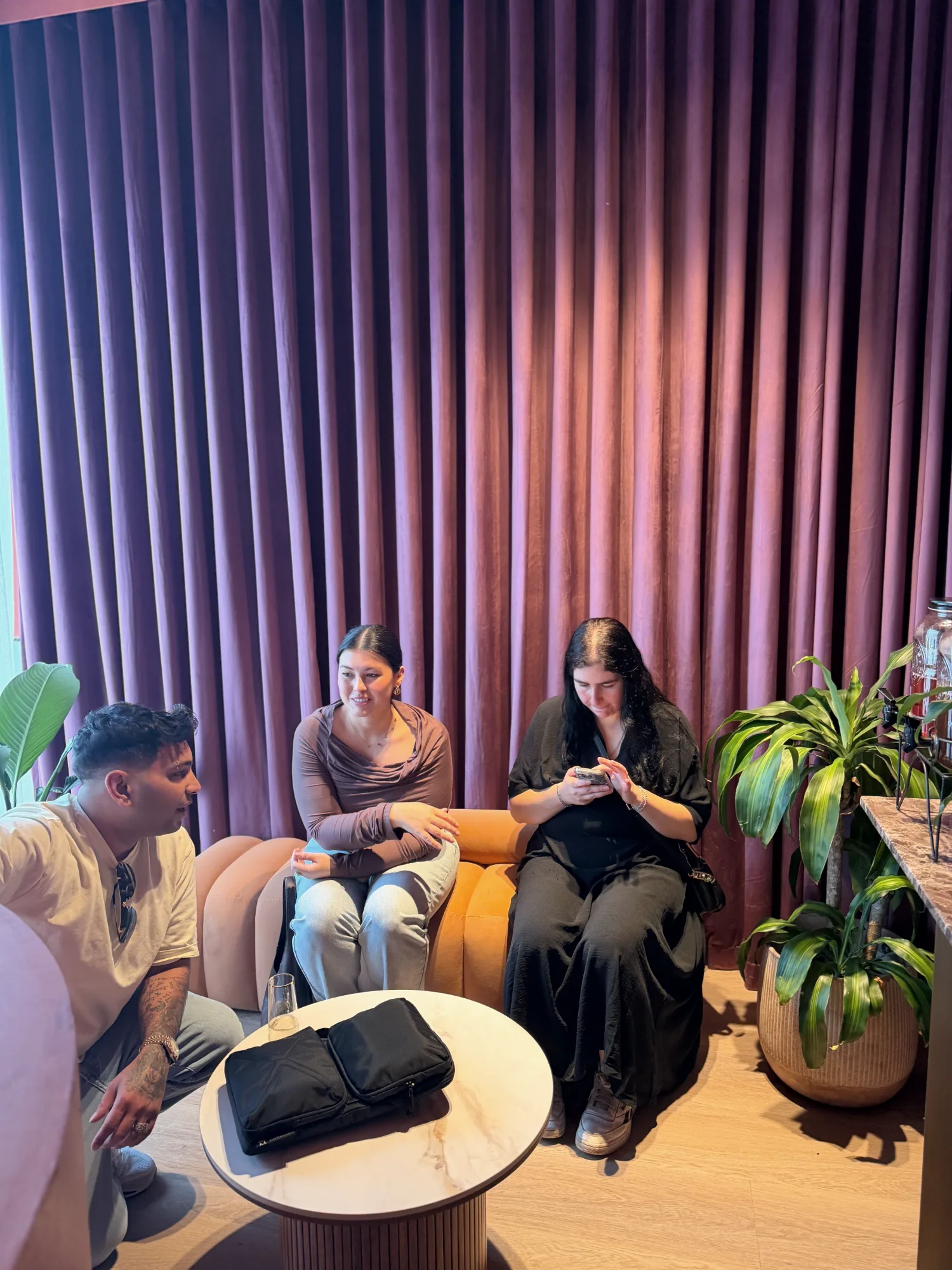 Guests seated in the velvet-curtained lounge