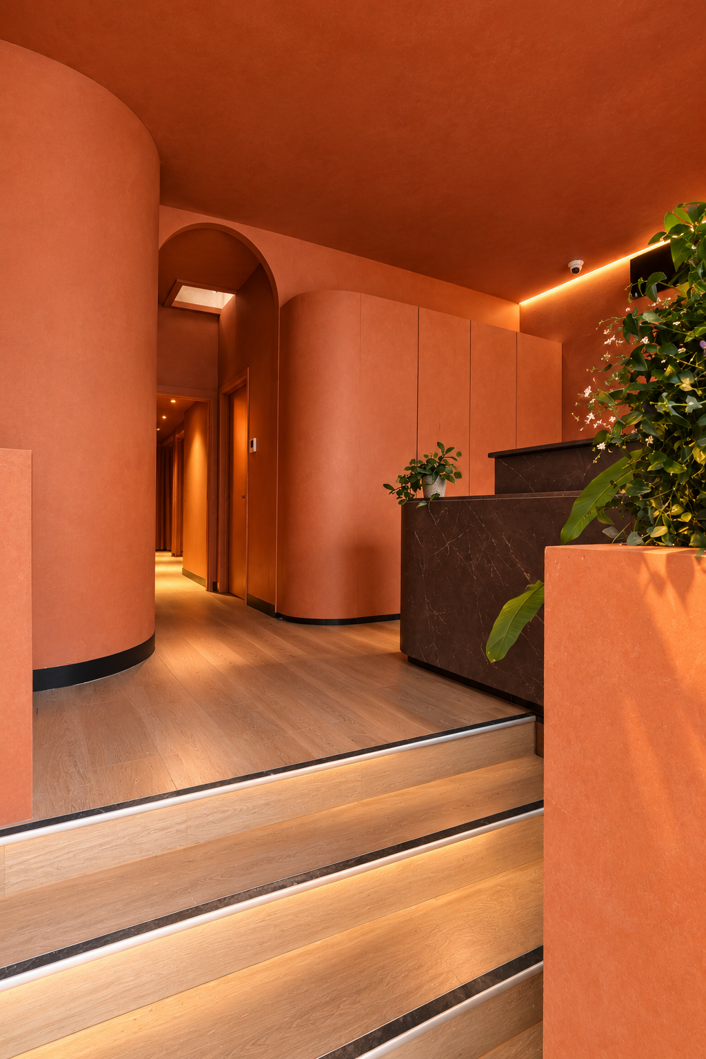 Terracotta spa reception with arched doorway and marble desk at Heal Bath House, East Brunswick
